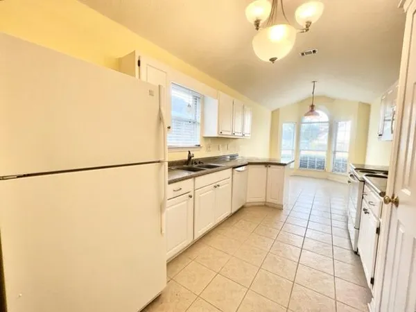 a kitchen with granite countertop a sink a stove and cabinets