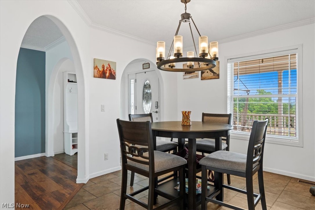 82 Patterson Ridge Road Rockport, WV 26169 - Photo 13 of 46 Dining area with an inviting chandelier, crown molding, and dark hardwood / wood-style flooring