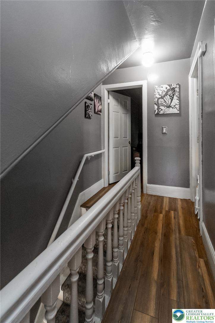 365 Rock Street Easton, PA 18042 - Photo 26 of 50 A well-lit second-story hallway with warm hardwood flooring and a classic white banister leading downstairs.