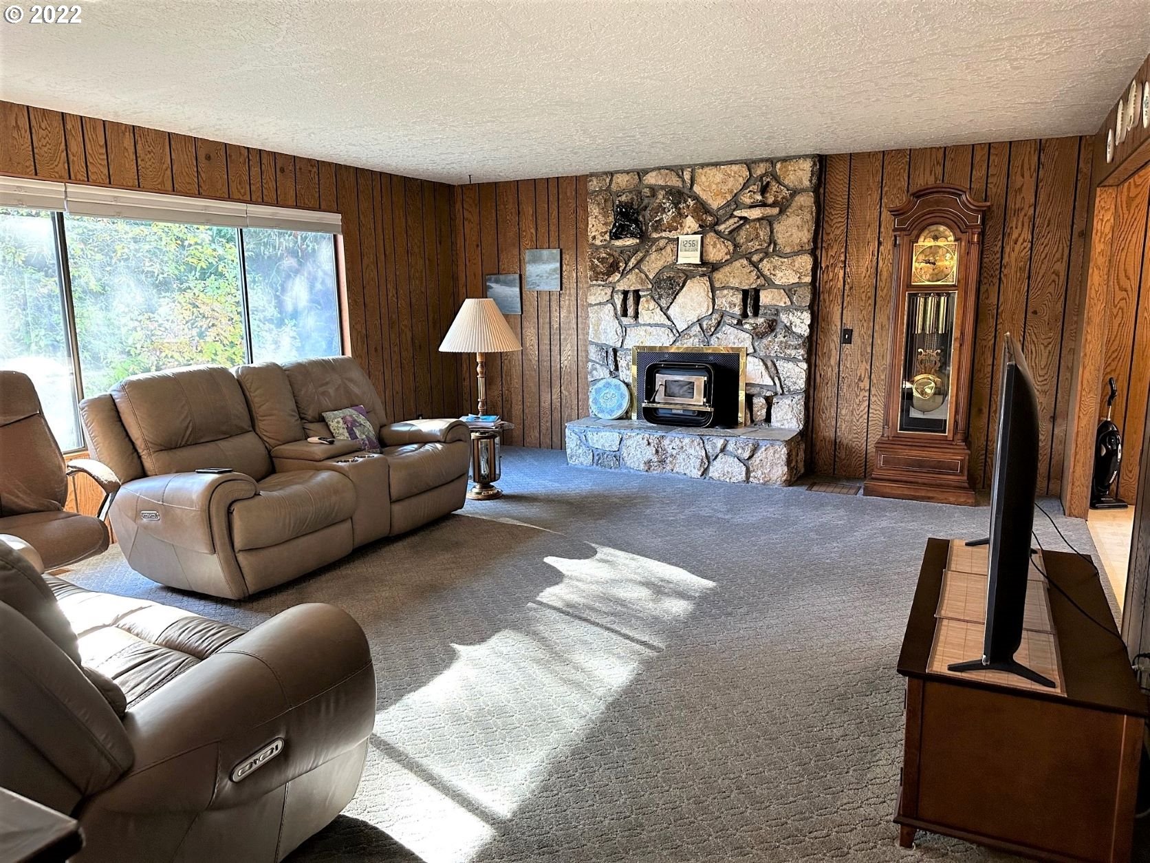 2026 Spring Brook Road Myrtle Creek, OR 97457 - Photo 12 of 32 a living room with furniture a fireplace and a large window