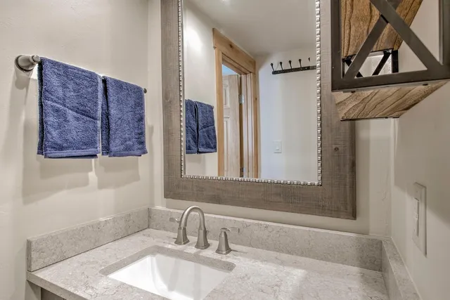 a bathroom with a granite countertop sink a mirror and shower