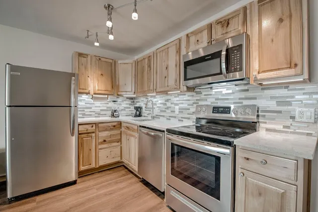 a kitchen with stainless steel appliances granite countertop a stove microwave and refrigerator