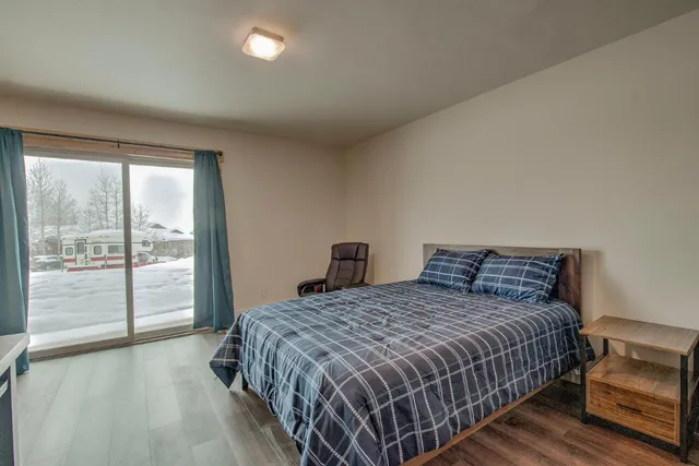 a bedroom with a bed and a large window