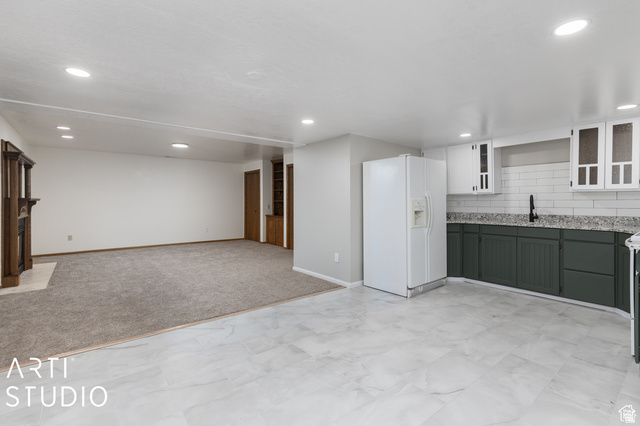 2807 North Ogden Canyon Road Eden, UT 84310 - Photo 37 of 72 Open-concept living space featuring a kitchenette with dark green lower cabinetry, white upper cabinetry, and a subway tile backsplash