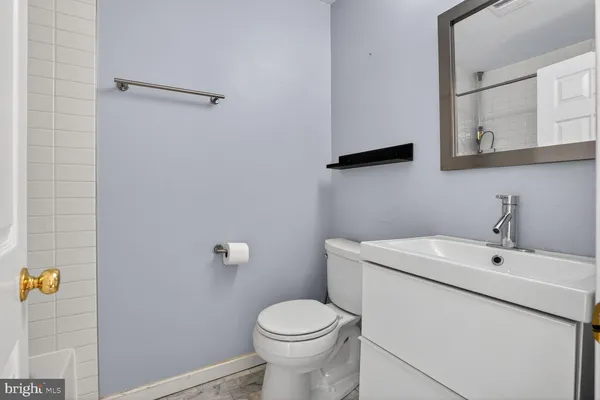 a bathroom with a sink a toilet and a mirror