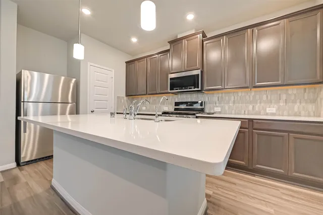 a view of kitchen island a sink and wooden floor