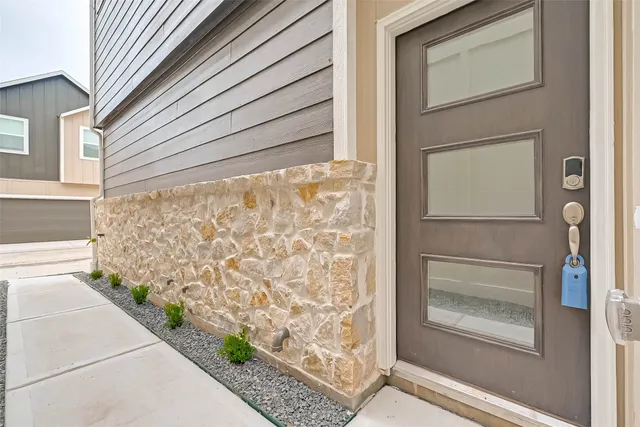 an empty room with wooden floor cabinet and windows