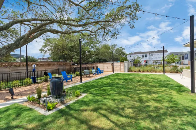 a view of a yard with a table and chairs under an umbrella