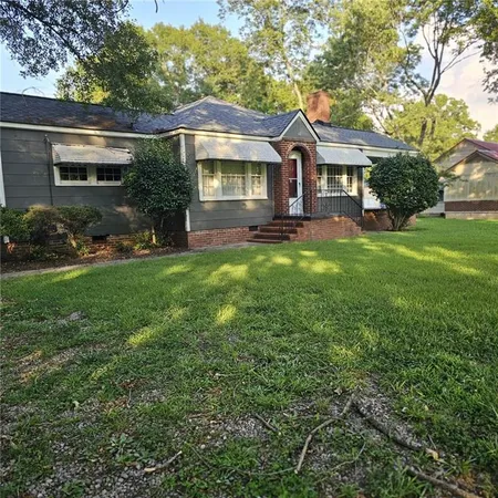 a front view of a house with yard and green space