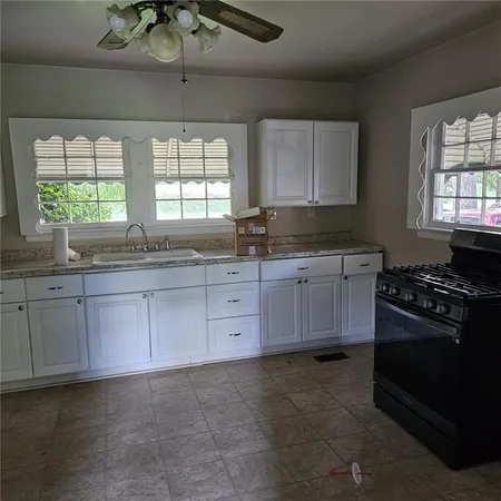 a kitchen with stainless steel appliances granite countertop a sink a stove and a granite counter tops