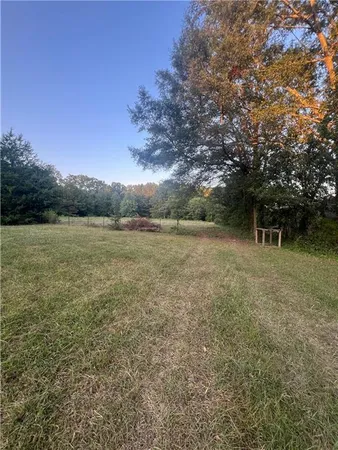 a view of a field with an trees in the background