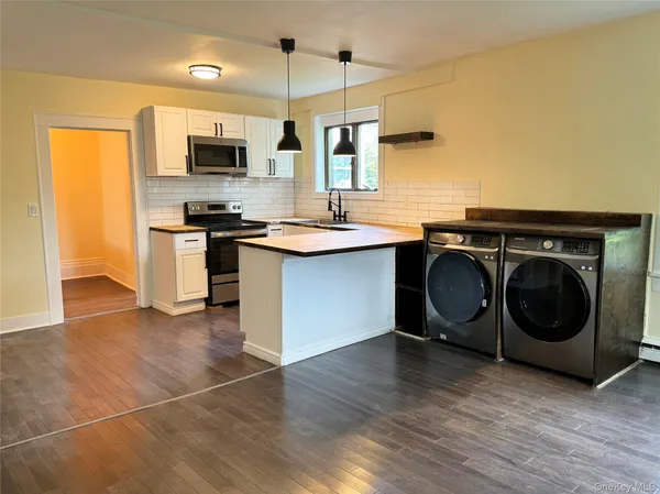 a kitchen with stainless steel appliances a stove a sink and a microwave