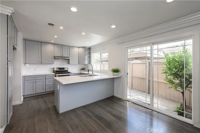 a kitchen with stainless steel appliances granite countertop a stove a sink and a refrigerator