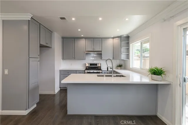 a kitchen with stainless steel appliances a sink stove and refrigerator