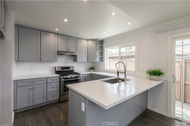 a kitchen with a sink a stove and cabinets