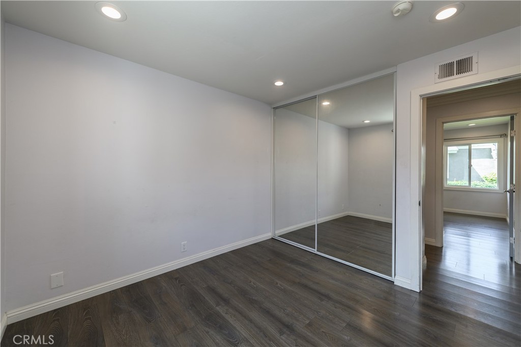2 Hollowglen, Unit 7 Irvine, CA 92604 - Photo 17 of 31 an empty room with wooden floor and windows