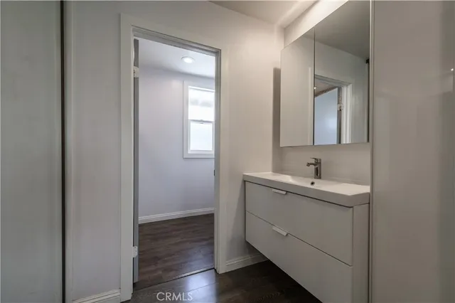 a view of bathroom with sink mirror and window