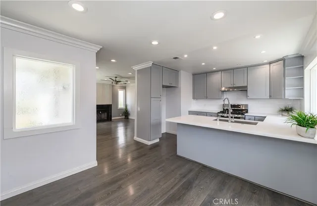 a kitchen with stainless steel appliances granite countertop a sink a stove a refrigerator and a window