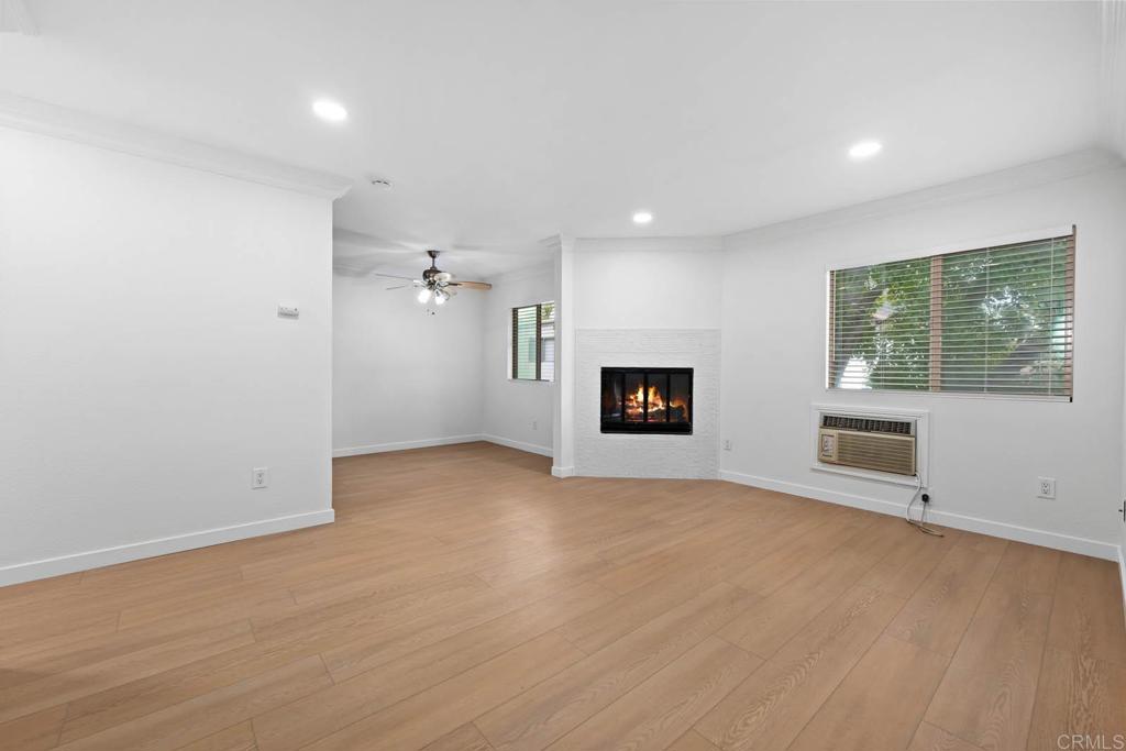 an empty room with windows and fireplace