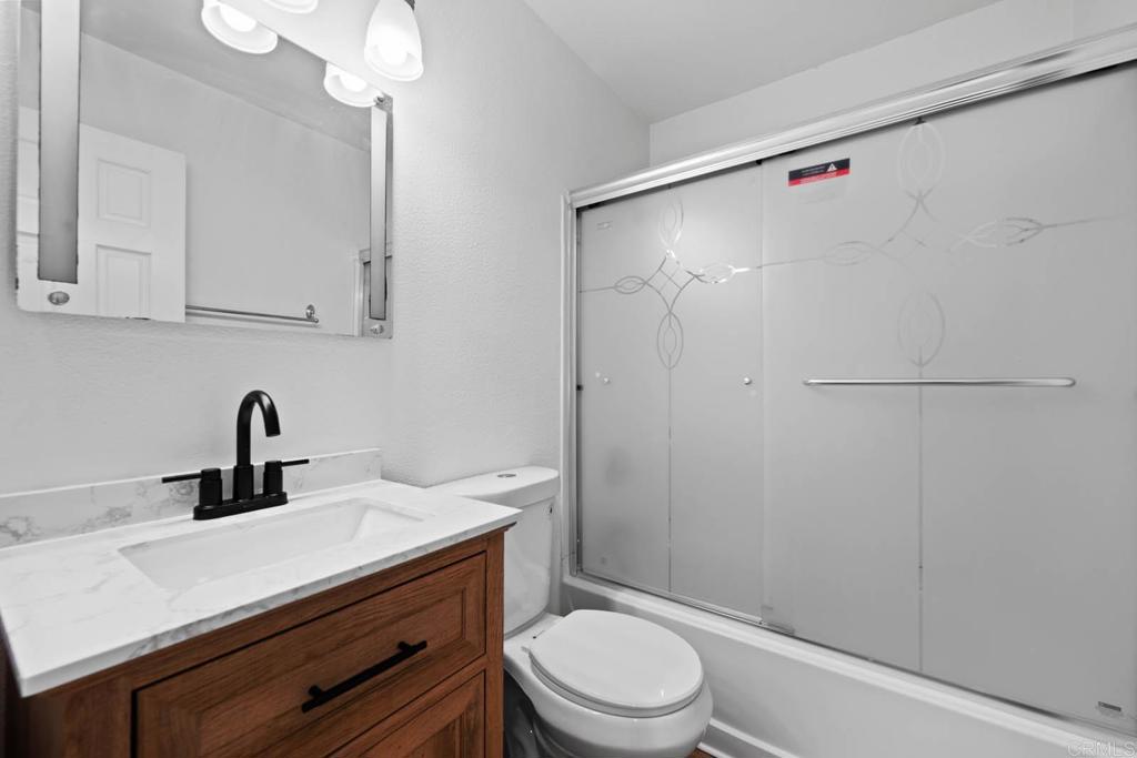 855 East Lexington Avenue, Unit 4 El Cajon, CA 92020 - Photo 5 of 12 a bathroom with a sink a mirror a toilet and shower