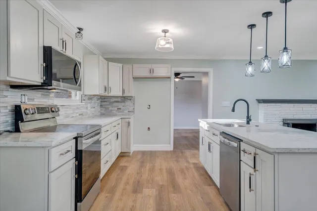 a kitchen with stainless steel appliances granite countertop a sink stove and refrigerator