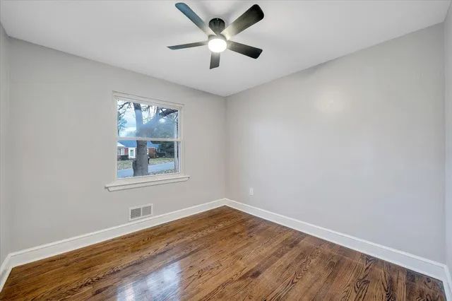 a view of empty room with wooden floor