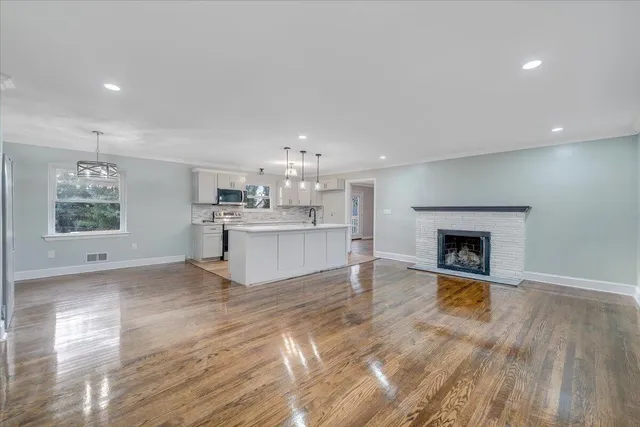 a view of a kitchen with a fireplace a sink and a window