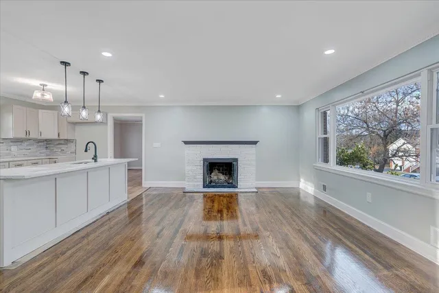 a large kitchen with a fireplace and wooden floor