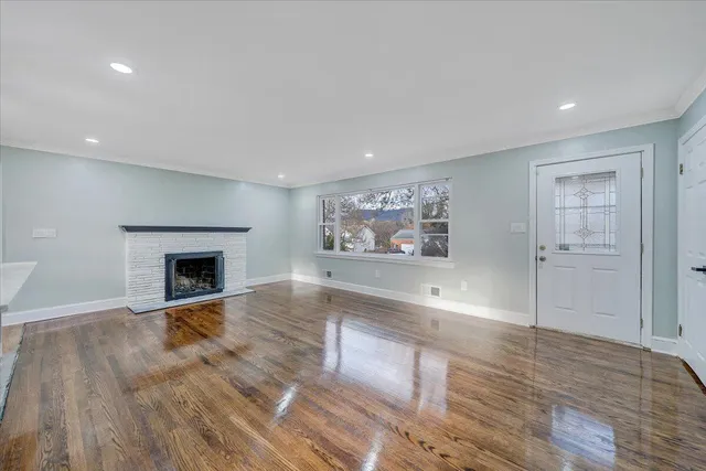 an empty room with windows and fireplace