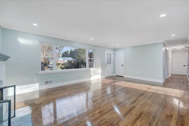 a view of a hallway with wooden floor and wall painting