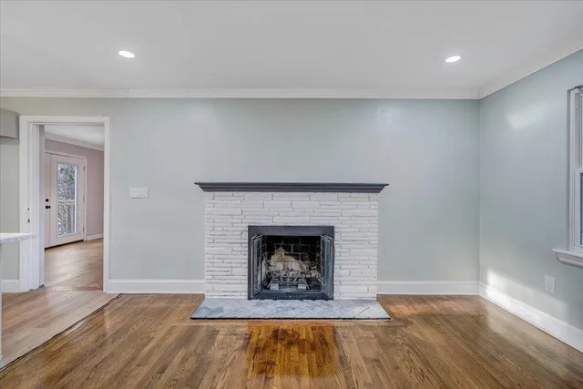 a living room with wooden floor and a fireplace