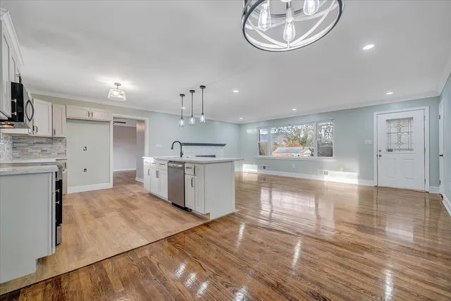 a open kitchen with white cabinets and stainless steel appliances
