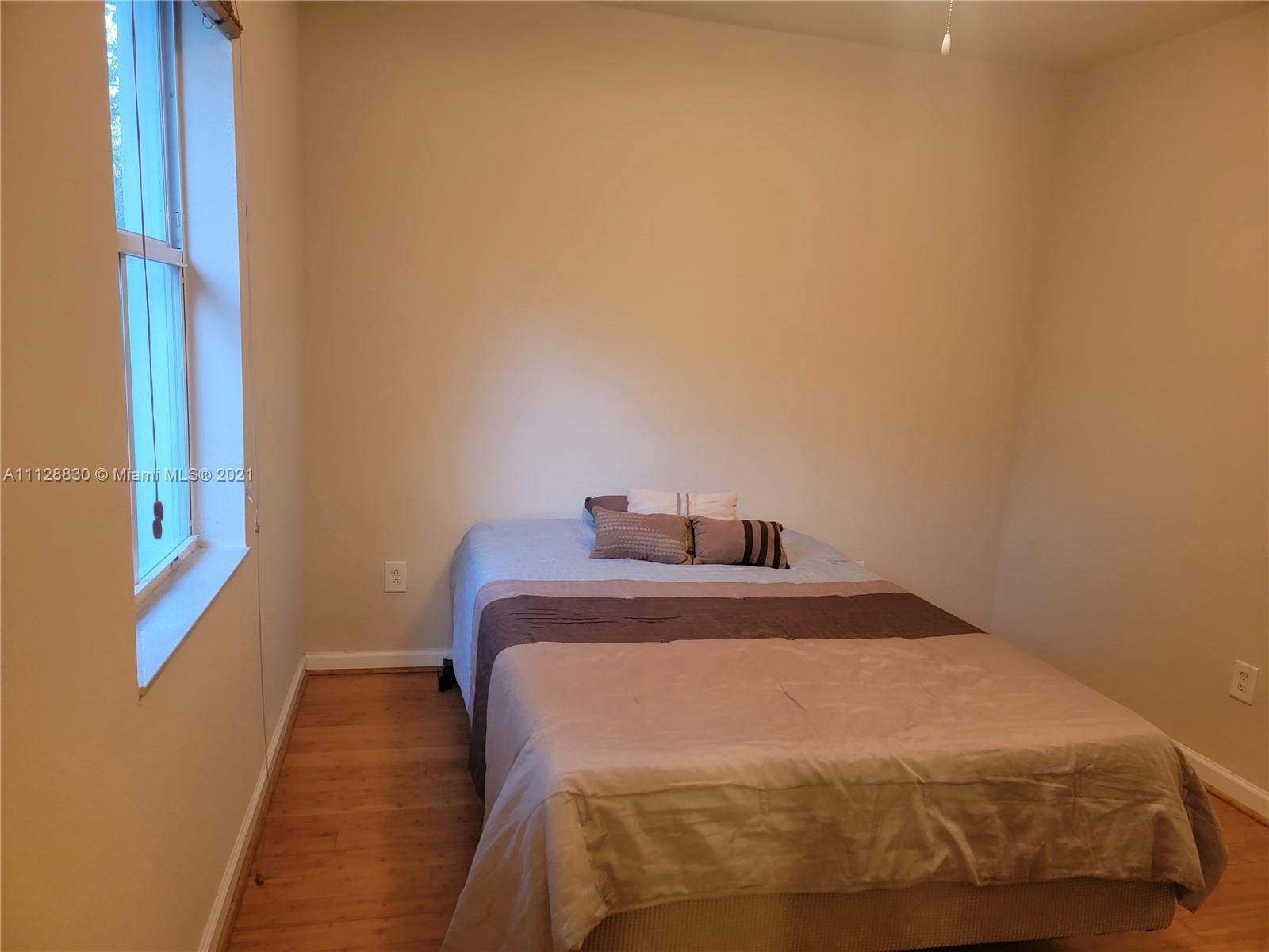 152 Southeast 29th Avenue, Unit 3 Homestead, FL 33033 - Photo 14 of 28 a bedroom with a bed and a window