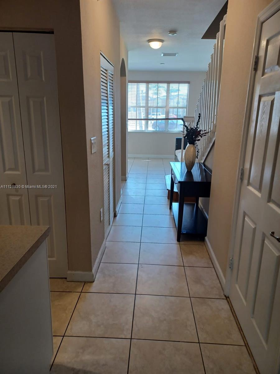 152 Southeast 29th Avenue, Unit 3 Homestead, FL 33033 - Photo 10 of 28 a hallway with dining area and glass windows