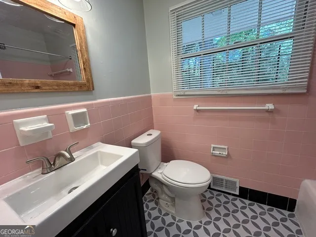 a bathroom with a sink a toilet and a mirror