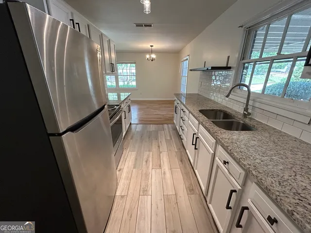 a kitchen with sink a refrigerator and window