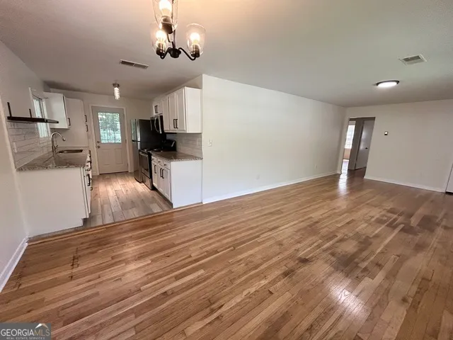 a view of a kitchen with wooden floor and a kitchen island
