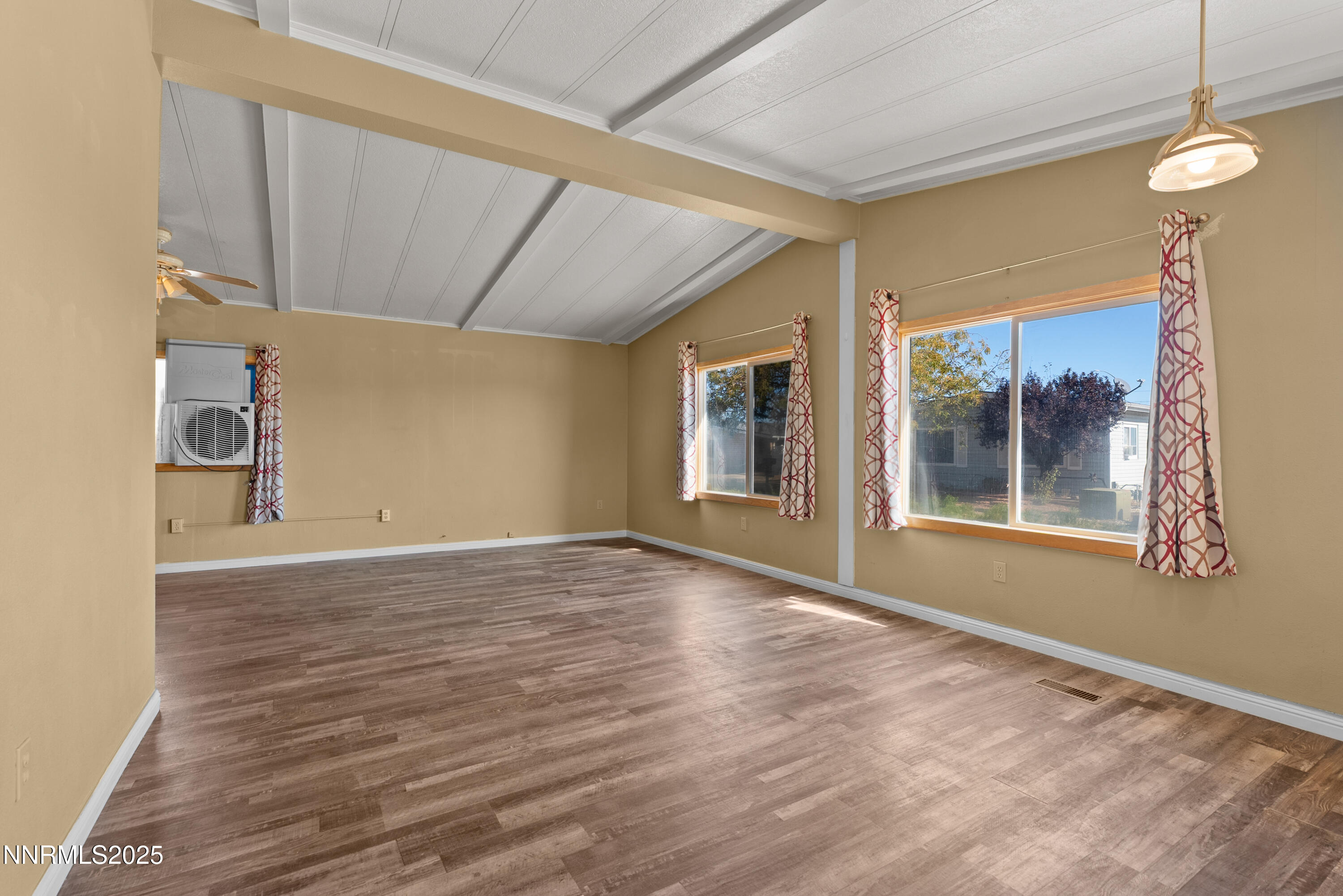 325 Parkland Way Fernley, NV 89408 - Photo 5 of 35 a view of an empty room with a window and wooden floor