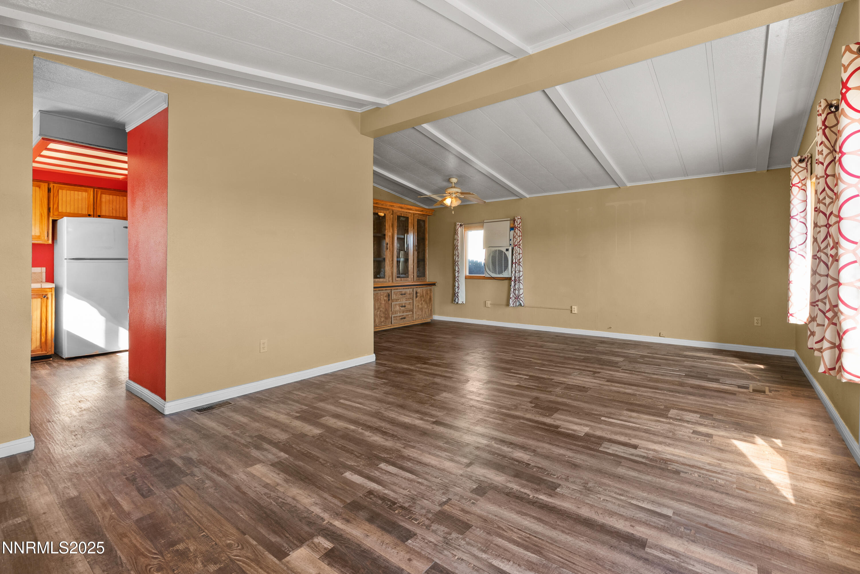 325 Parkland Way Fernley, NV 89408 - Photo 6 of 35 a view of an empty room with window and wooden floor