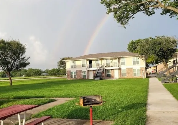 a view of a big house with a big yard and large trees