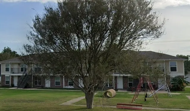 a view of a big house with a big yard and large trees