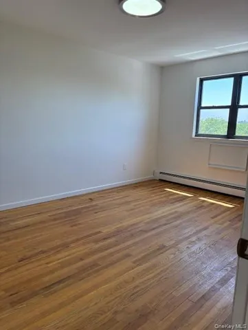 a view of a room with wooden floor and window