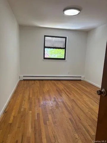 a view of a room with wooden floor and window