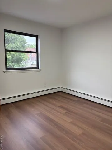 an empty room with wooden floor and window