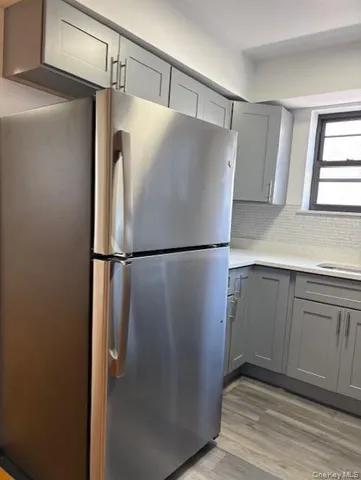 a view of a refrigerator in kitchen and white cabinets