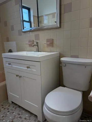a white toilet sitting next to a bathroom sink