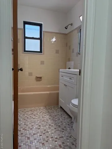 a bathroom with a granite countertop toilet a sink and bathtub