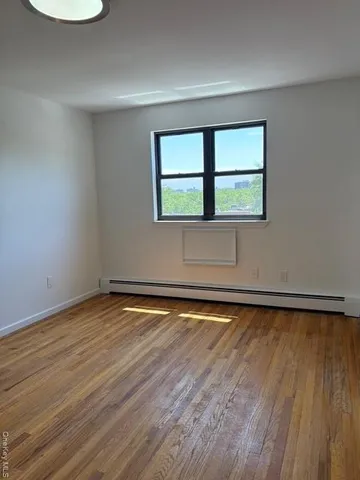 a view of a room with wooden floor and fan
