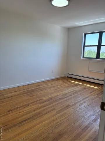 a view of a room with wooden floor and window
