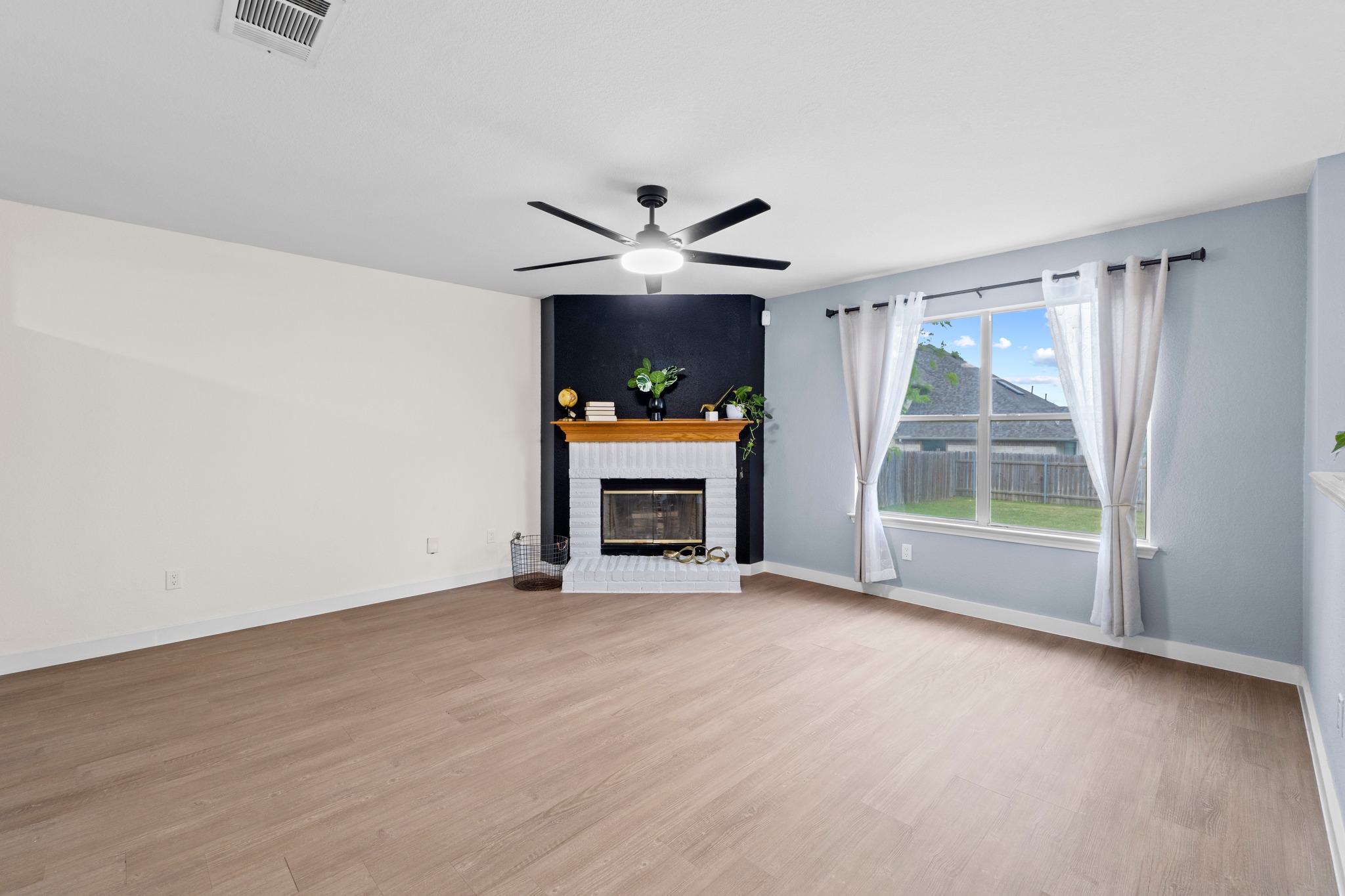 3811 Laurel Ridge Drive Round Rock, TX 78665 - Photo 12 of 35 a view of an empty room with a fireplace and a window